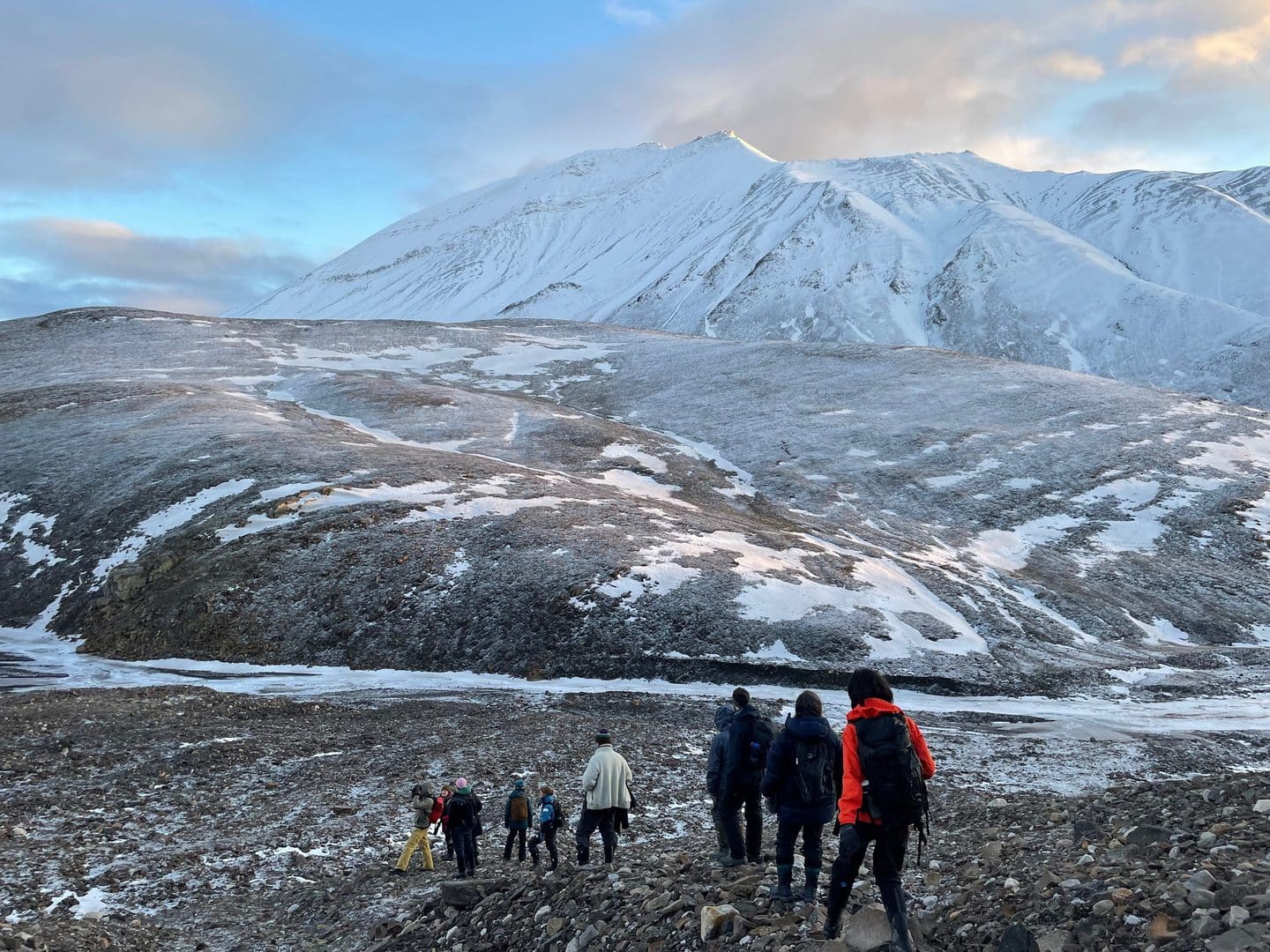 a group of people walking on a rocky mountain